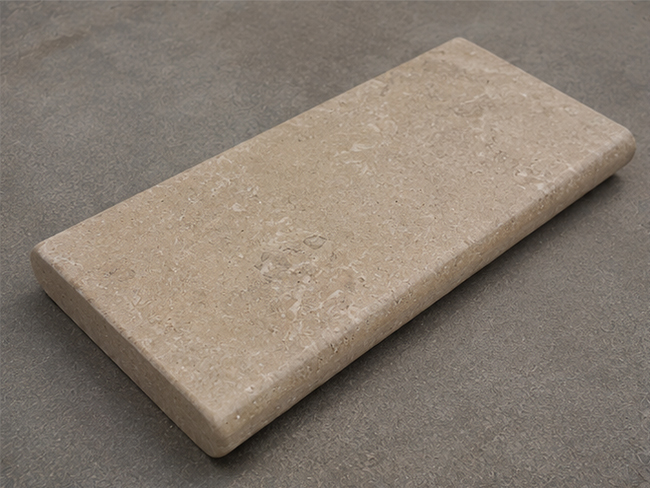 Natural beige limestone pool coping around outdoor swimming pool