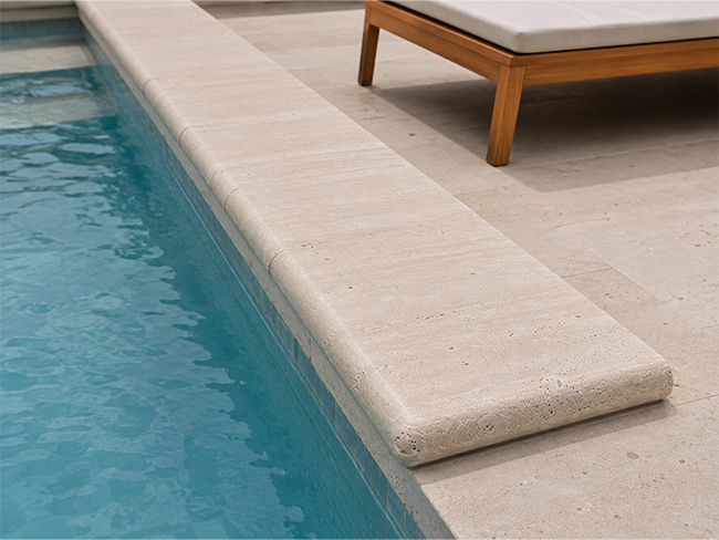 Tumbled travertine pool coping with textured natural stone surface